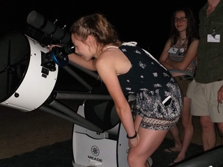 Chica observando por el telescopio